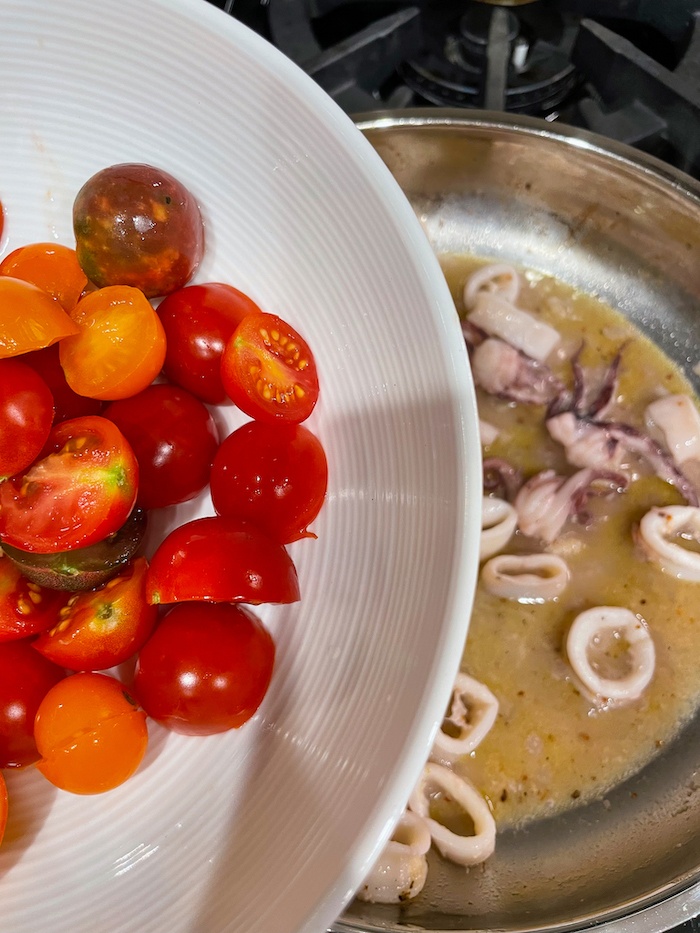 adding cherry tomatoes to the pot