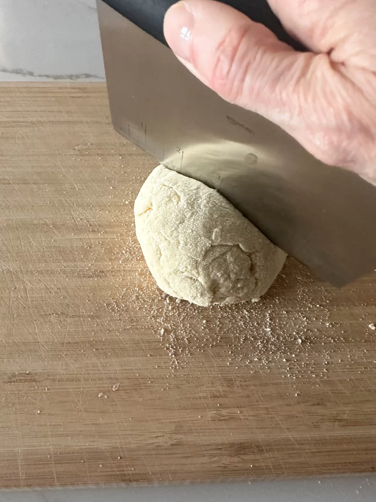 Cutting dough on a board with a pasta scraper