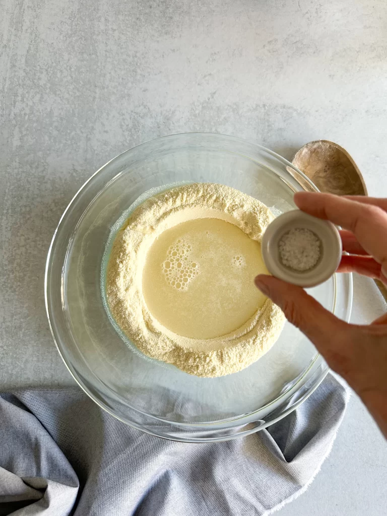 Water added to flour and hands adding salt