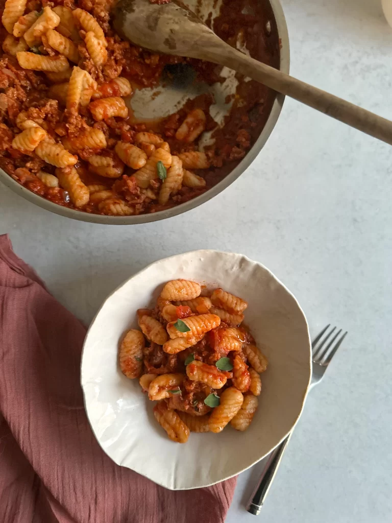 Pot with a white bowl of cavatelli on side