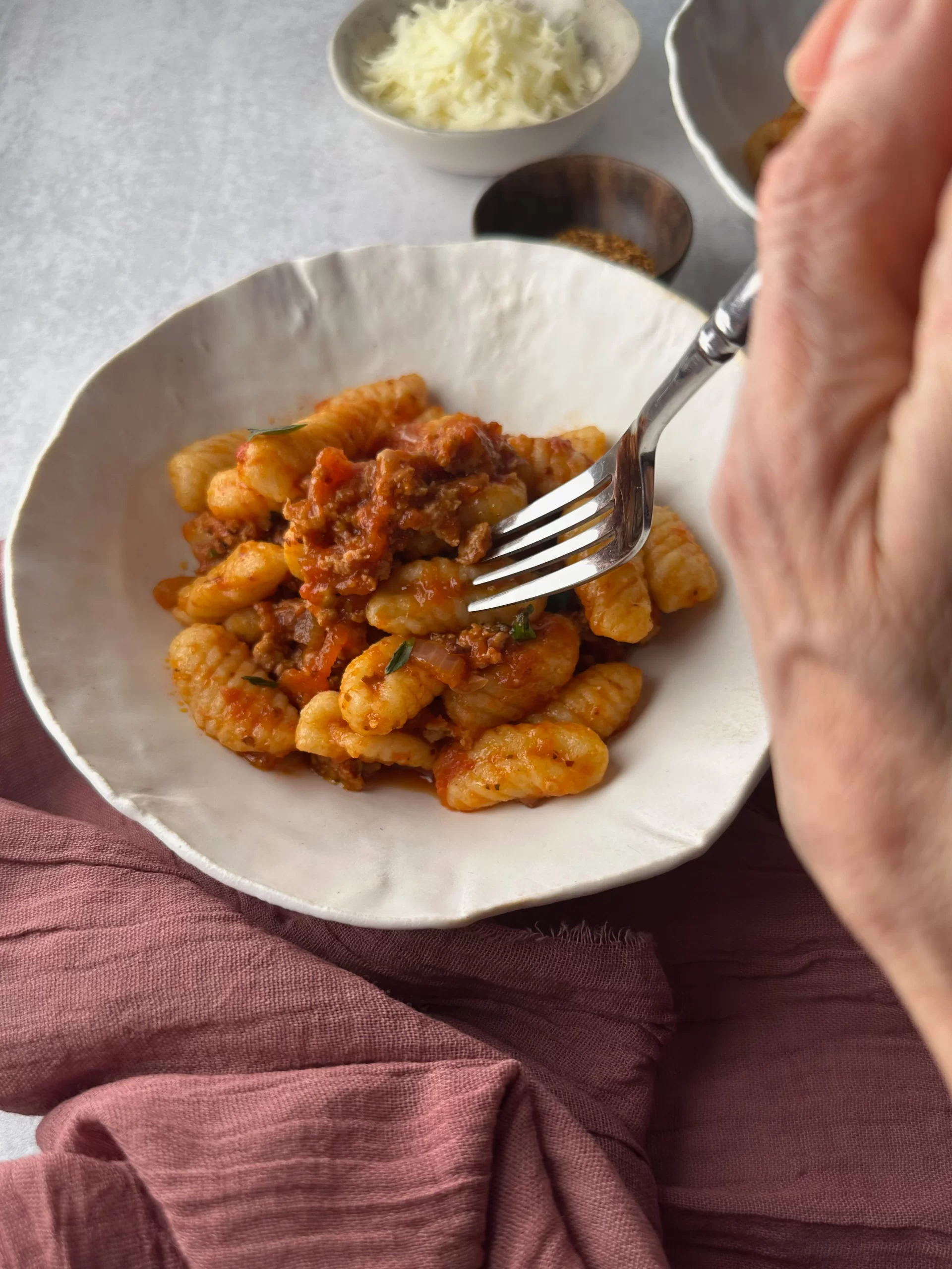 Fork in a bowl of cavatelli with spicy Italian Sausage