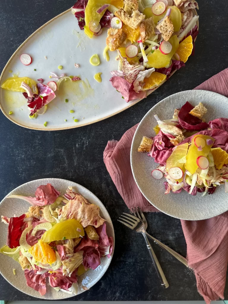 2 plates and the serving plate with winter panzaneella salad